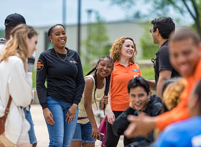 Group of Students talking outside, on campus.