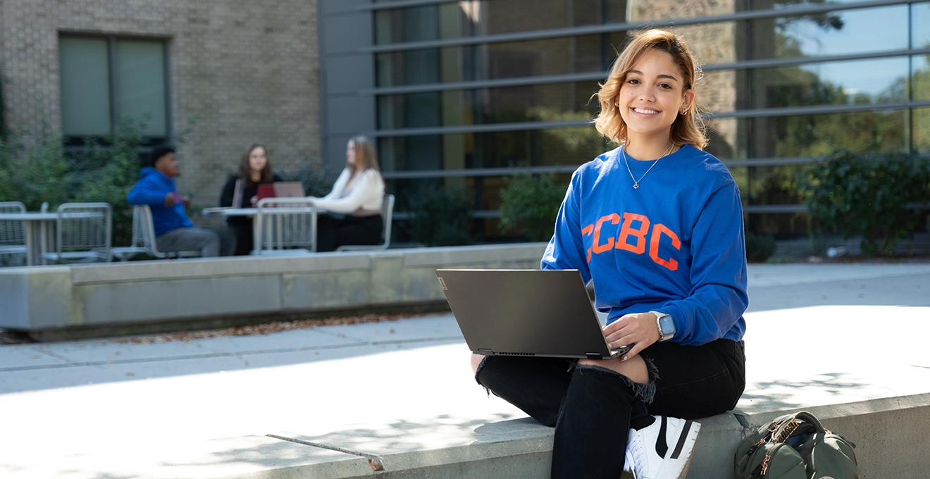 student sitting outside with laptop