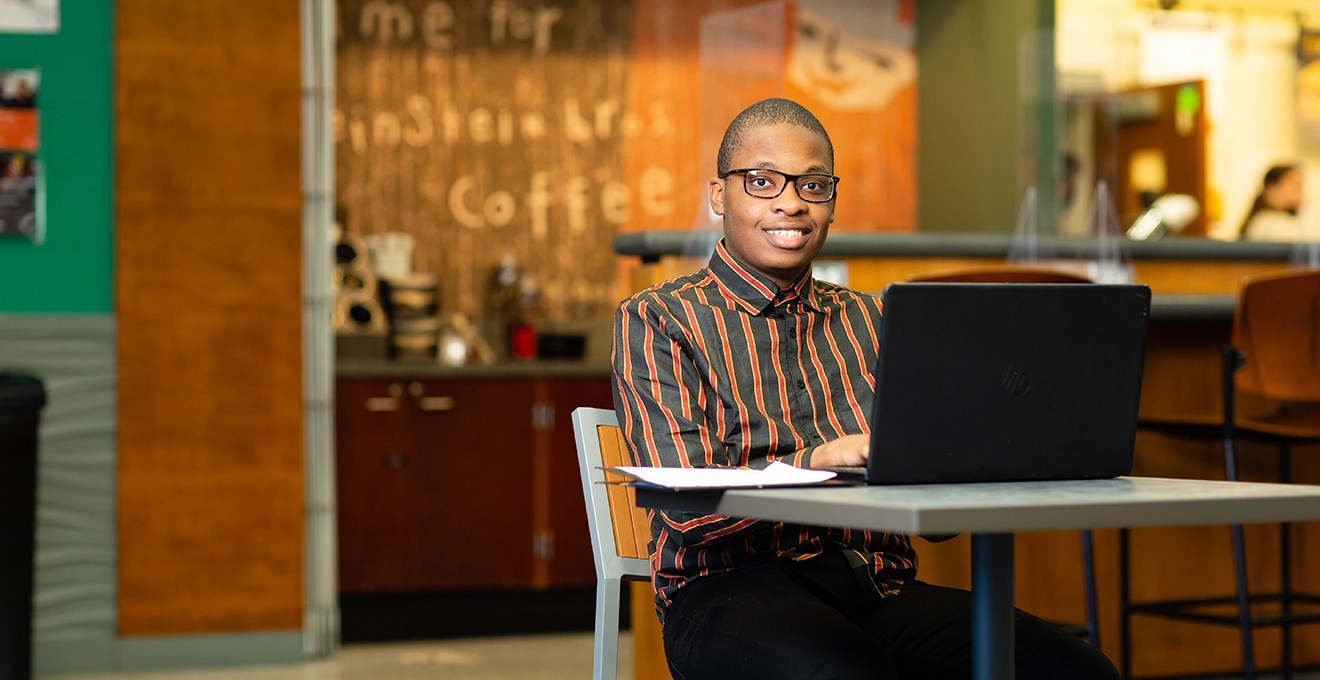 Photo of student seated with laptop