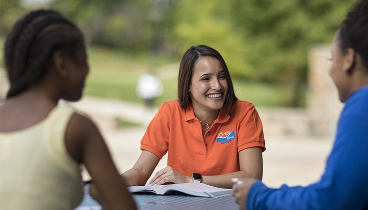 Student ambassador smiles holding a folder