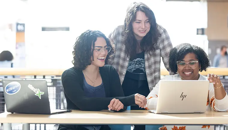     Three students studying together on a laptop