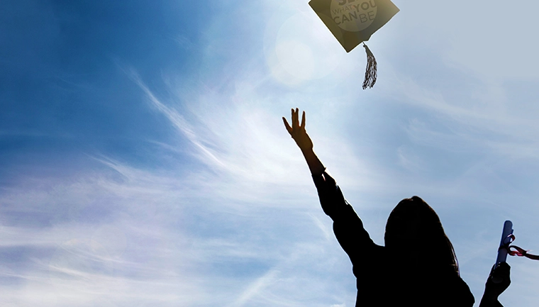 Woman tossing graduation cap