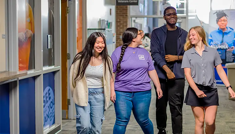 Group of students walking and talking in a hallway