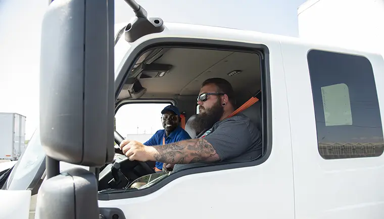 Two men in a white truck.