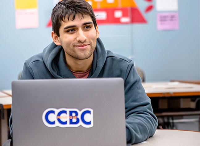 Student in class working on his laptop