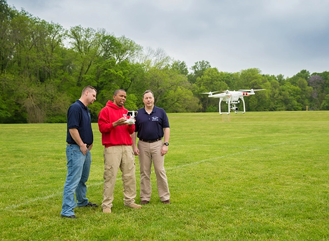 Three men flying a drone