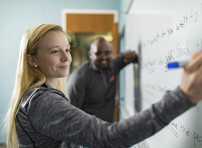 student writing on white board