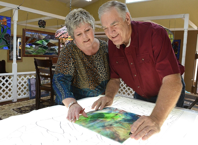 Two adults making stained glass
