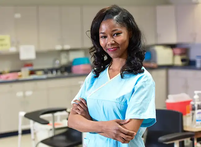 Student wearing scrubs standing in medical office