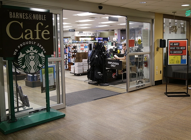 CCBC Bookstore entrance door showing Barnes and Nobles and Starbucks logos and a poster saying we have what you need to succeed on the door