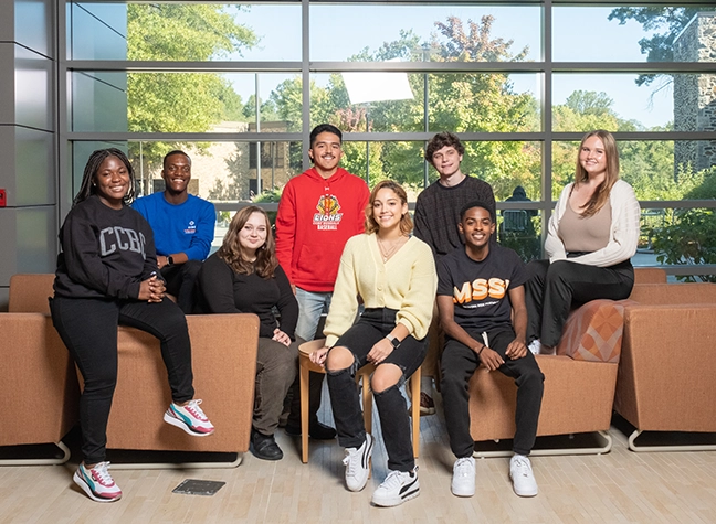 A Group of CCBC Fresh Faces students sitting together in a lobby. 