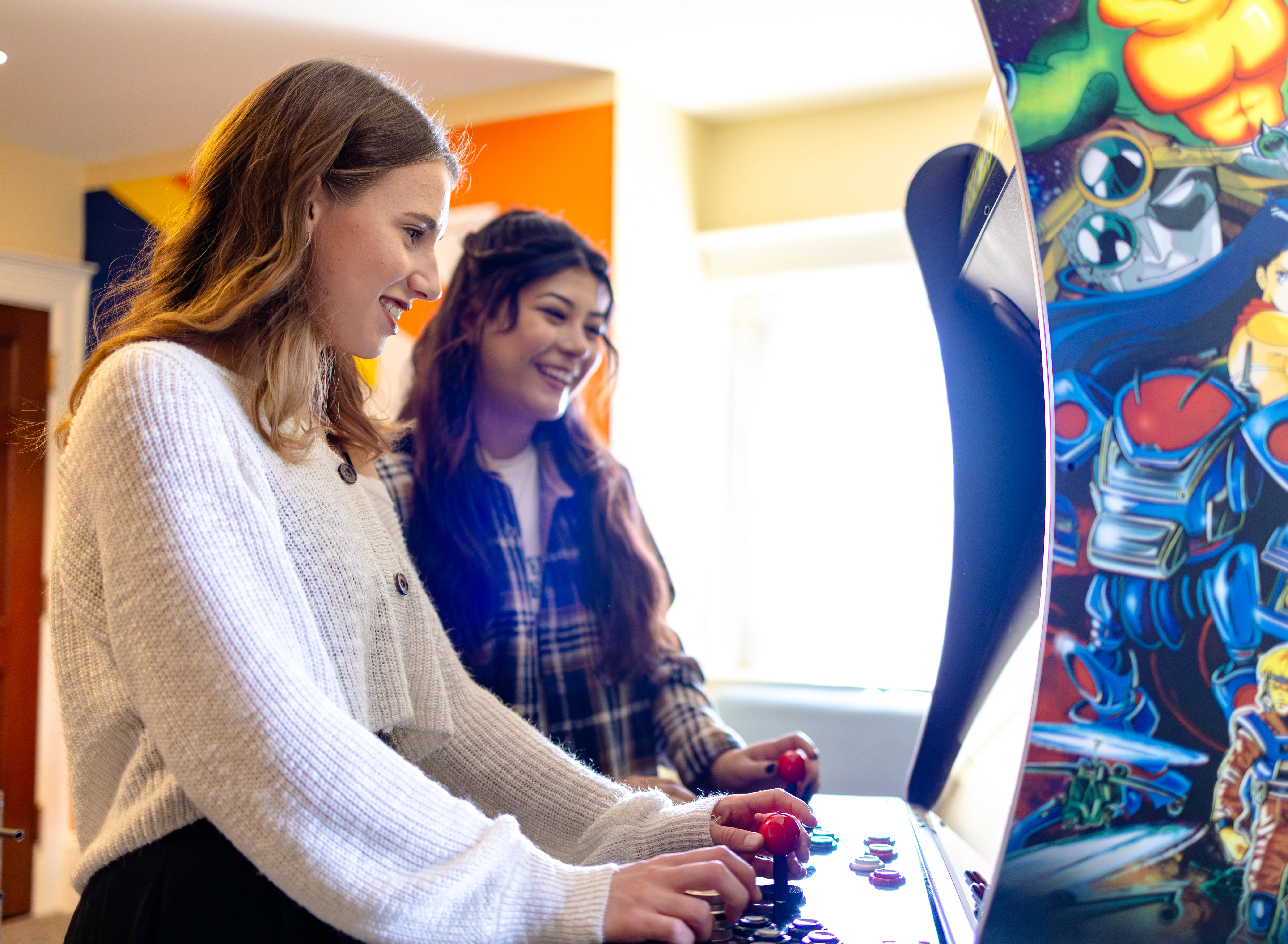 Two students playing a game of pinball.