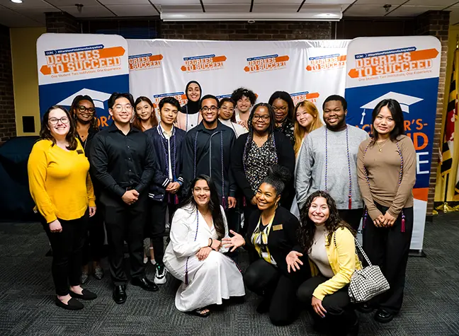 Three students who are all transferring to UMBC from CCBC stand together holding a "You did it!" sign.