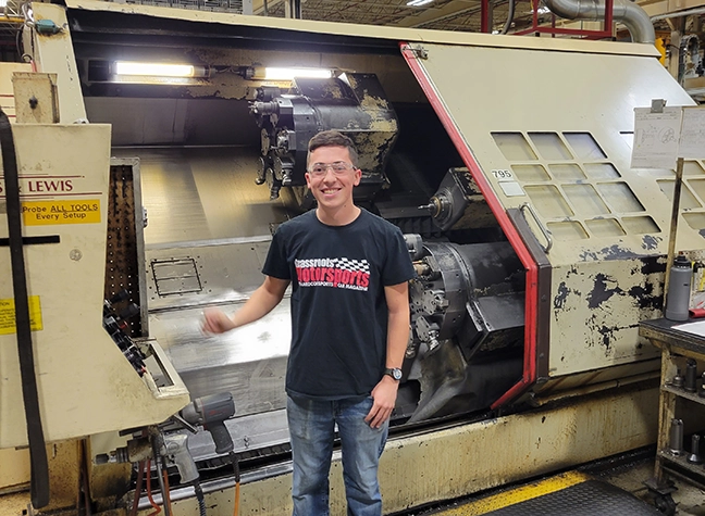 Cole Stevens in front of a CNC machine