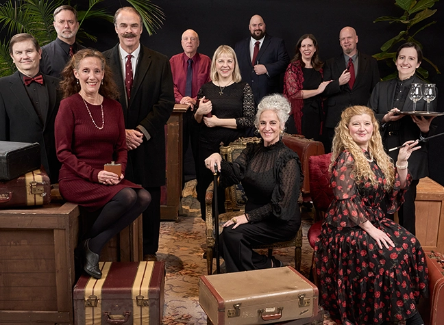 Photo of actors on stage dressed for a train ride