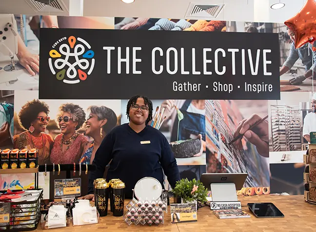 Photo of a student standing beneath a sign that reads "Collective"