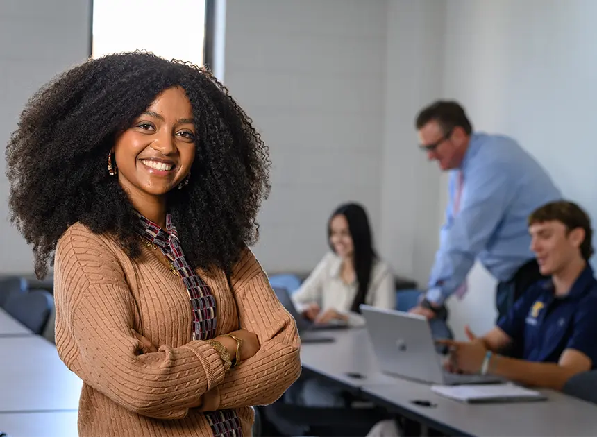 Student smiling in front of classroom